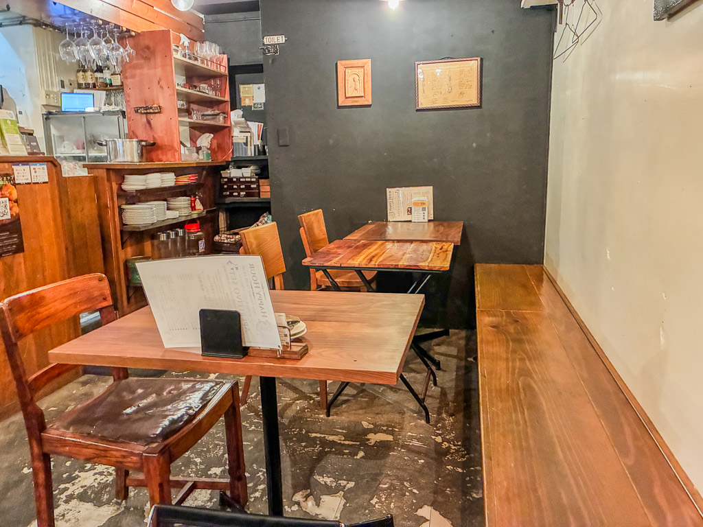 ALGOS DELI×HAMBURG（アルゴス デリ×ハンバーグ）桌位區 — 木桌椅與牆上裱框的菜單