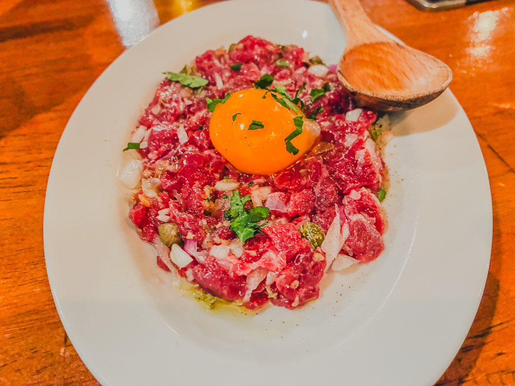 ALGOS DELI×HAMBURG（アルゴス デリ×ハンバーグ）義式塔塔生牛肉 — 切碎的生牛肉上鋪蛋黃，配酸豆與切碎洋蔥
