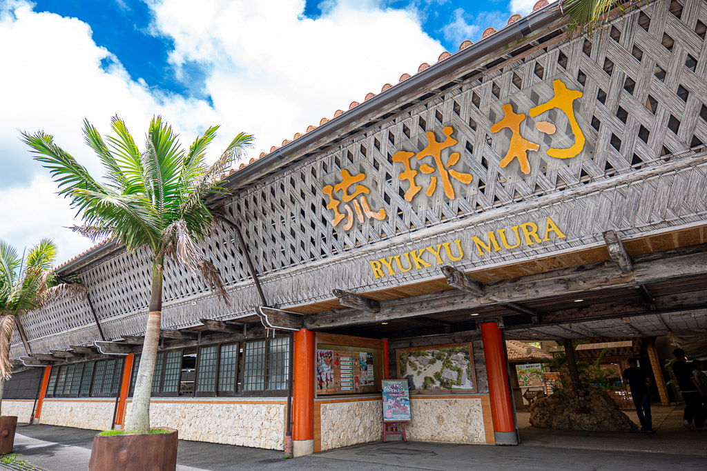 琉球村正門 — 巨大的編織風屋頂與黃色琉球村招牌 RYUKYU MURA