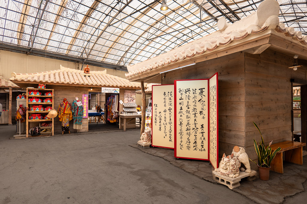 琉裝體驗區 — 紅黃色琉球王朝服飾與三線民謠書法屏風展示