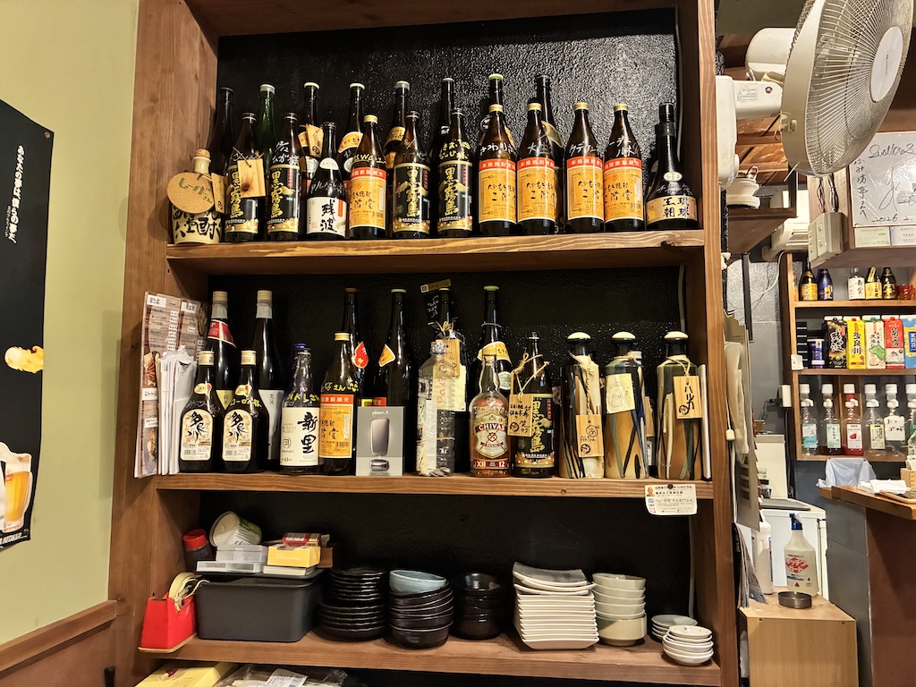 沖繩居酒屋的泡盛酒架，擺滿琉球本地酒款——用日本eSIM搜尋酒款資訊與評價