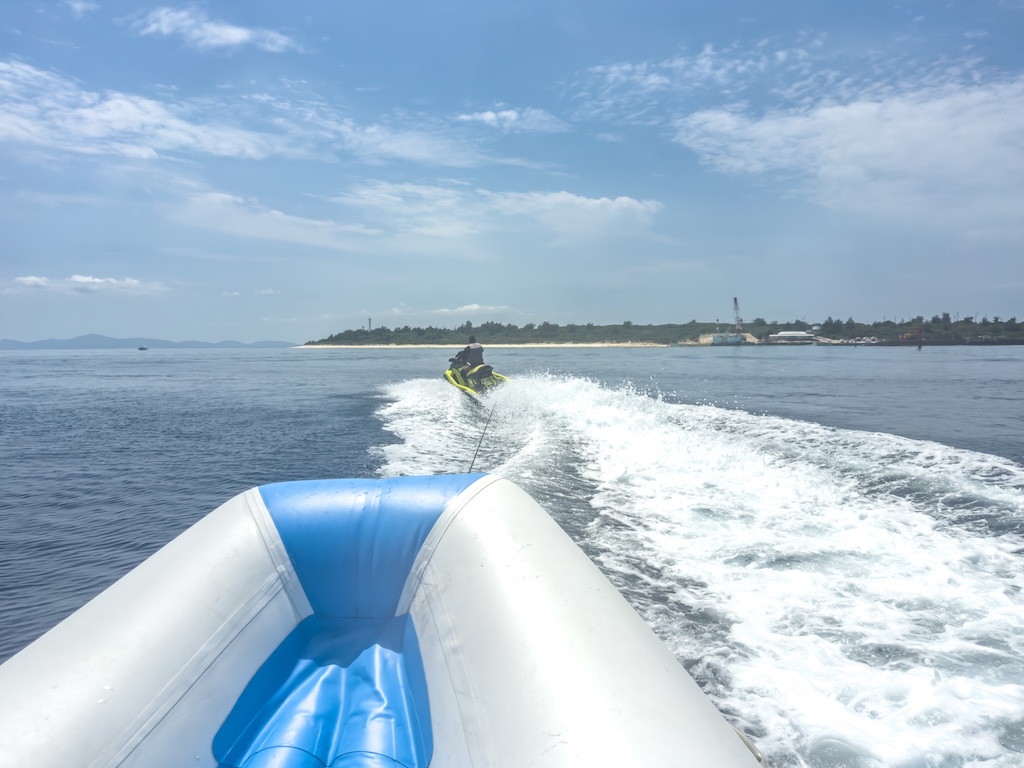 水納島海上活動 — 水上摩托車牽引浮胎遠望水納島海灘的廣角畫面