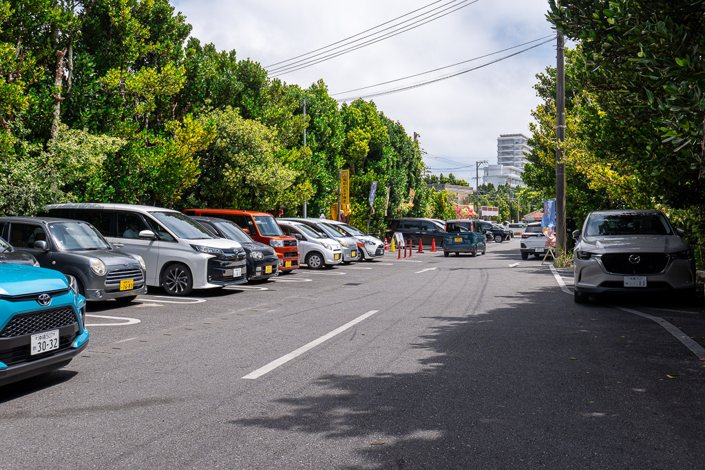 備瀬福木林道入口附近私人經營的收費停車場停滿租借車