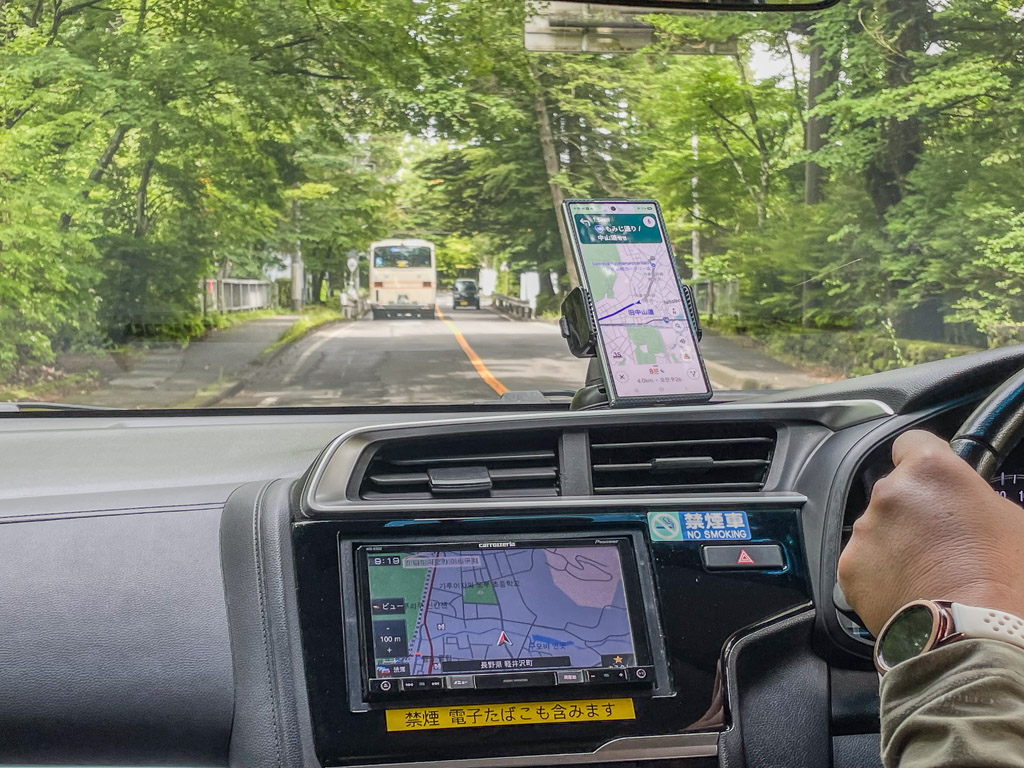 租車儀表板上手機支架的Google Maps畫面與下方日文原廠導航