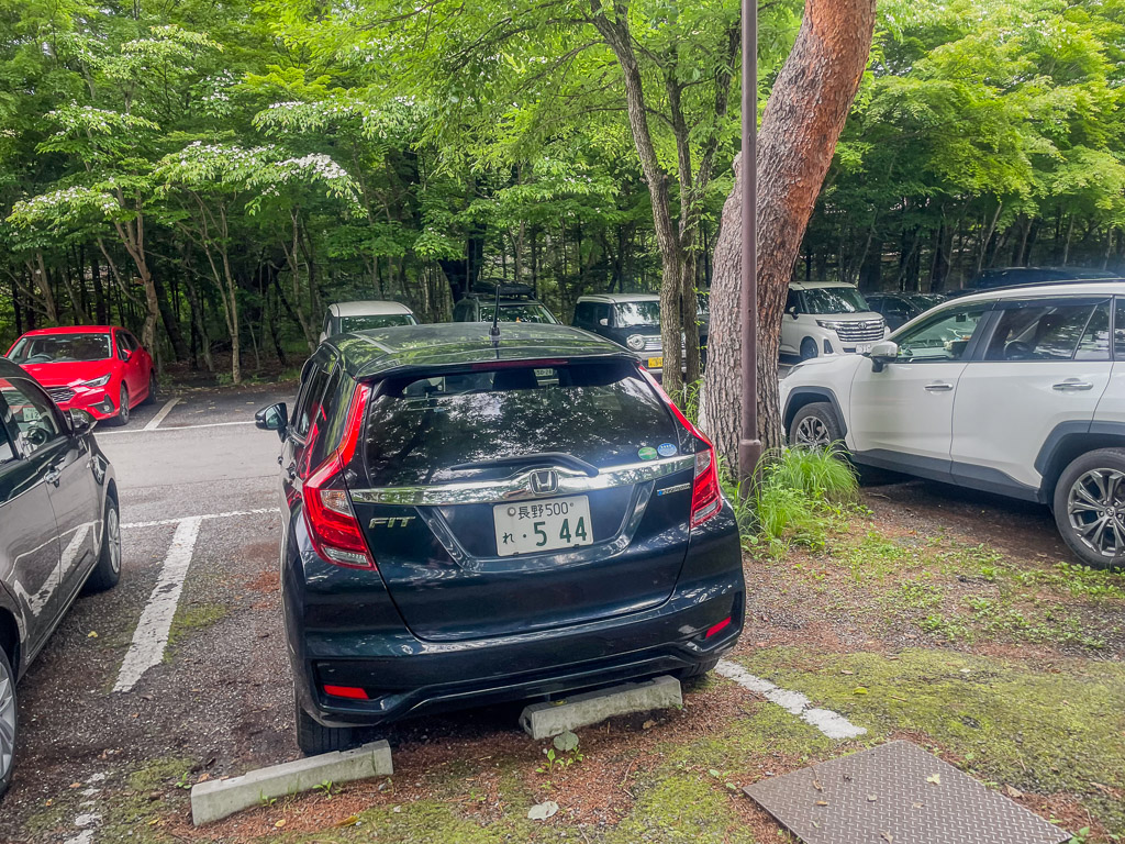 長野租車Honda FIT車尾停在森林邊的停車格
