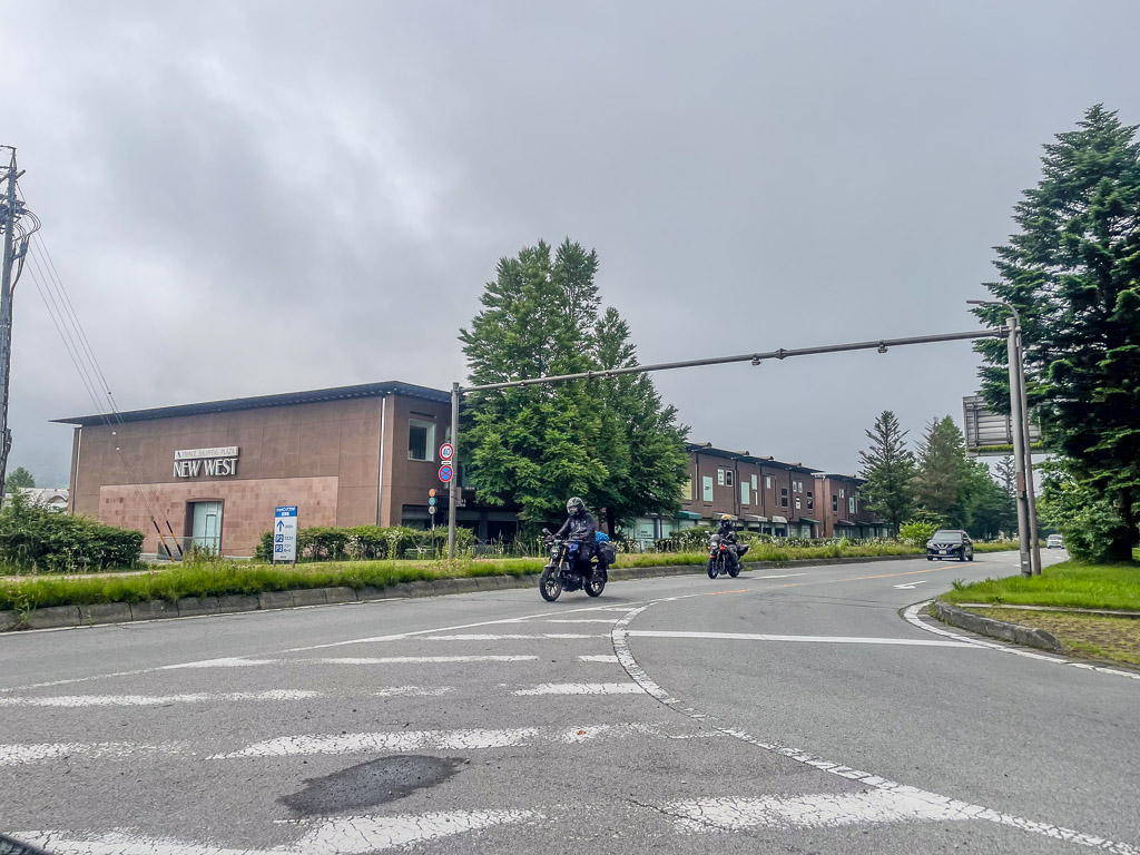 輕井澤NEW WEST建築前的道路與騎機車經過的兩位騎士