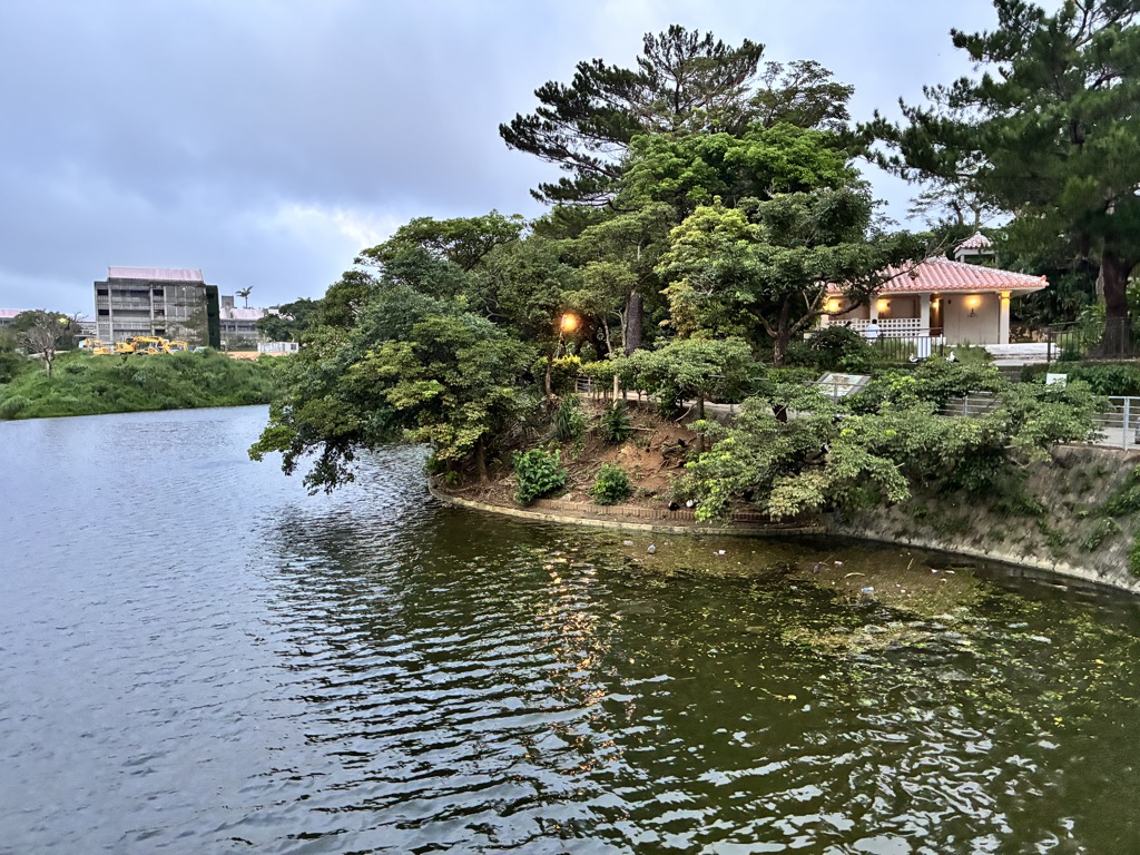 傍晚亮起燈火的紅瓦建築與首里城公園水池
