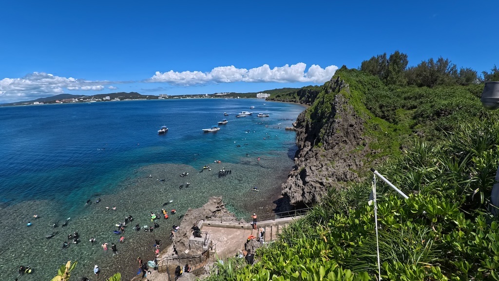 穿浮潛面鏡和蛙鞋的旅客在沖繩青洞水中