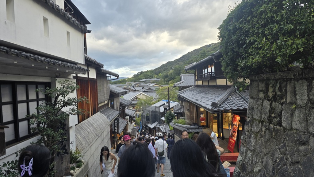 三年坂石板路兩旁的傳統木造町家與傍晚時分的觀光客