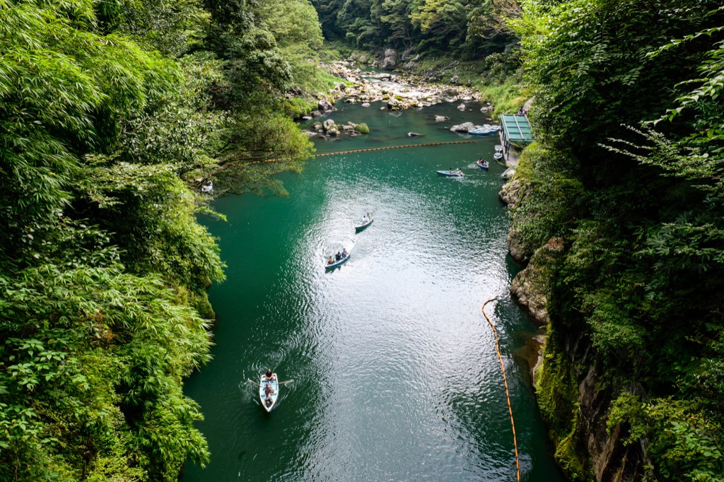 從高處俯看高千穗峽藍綠色河道上的小船
