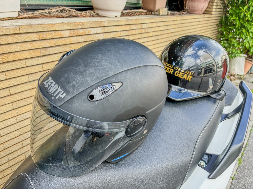 機車座墊上的兩頂安全帽，方案含一頂免費安全帽
